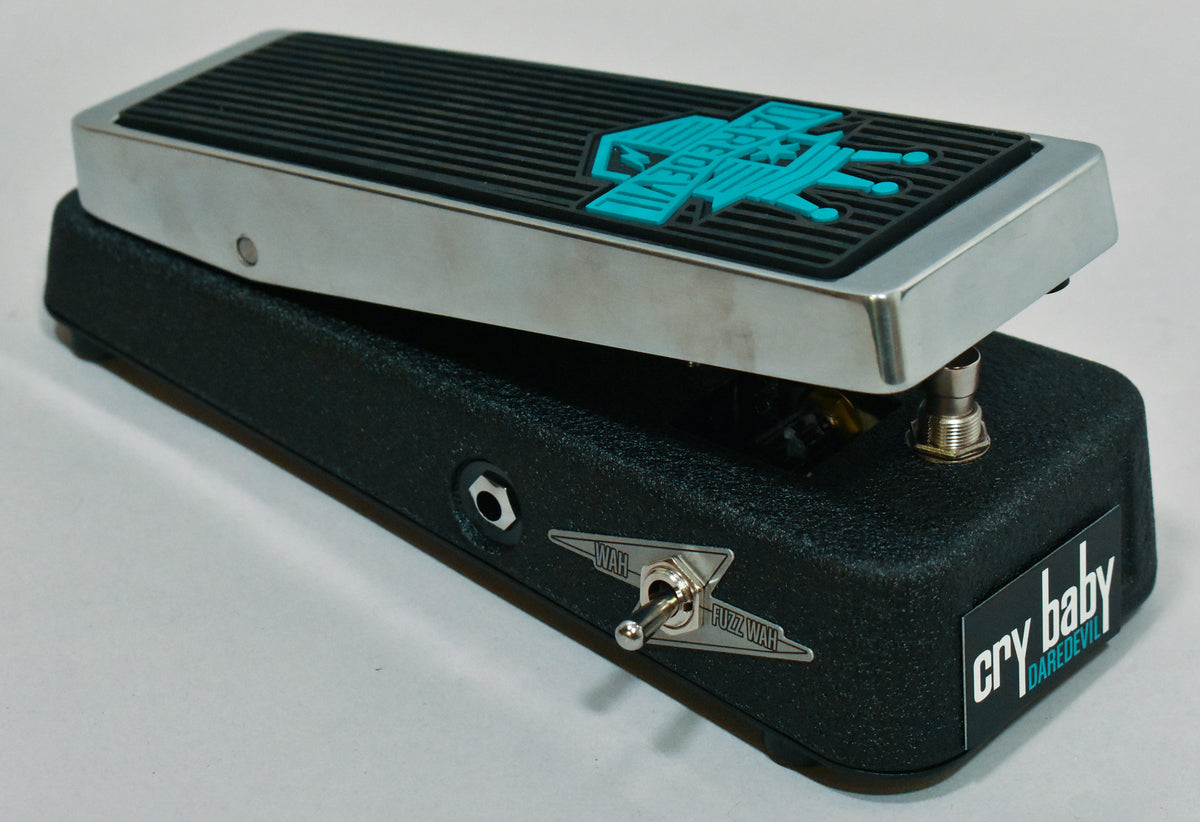 A black textured wah pedal with a chrome rocker, black ribbed footpad, and a teal "Daredevil" logo, angled to show the input jack and a "Wah/Fuzz Wah" toggle switch.