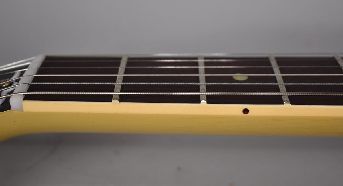 Close-up of the TV Yellow neck and dark fretboard with white binding, showing a single circular side marker.
