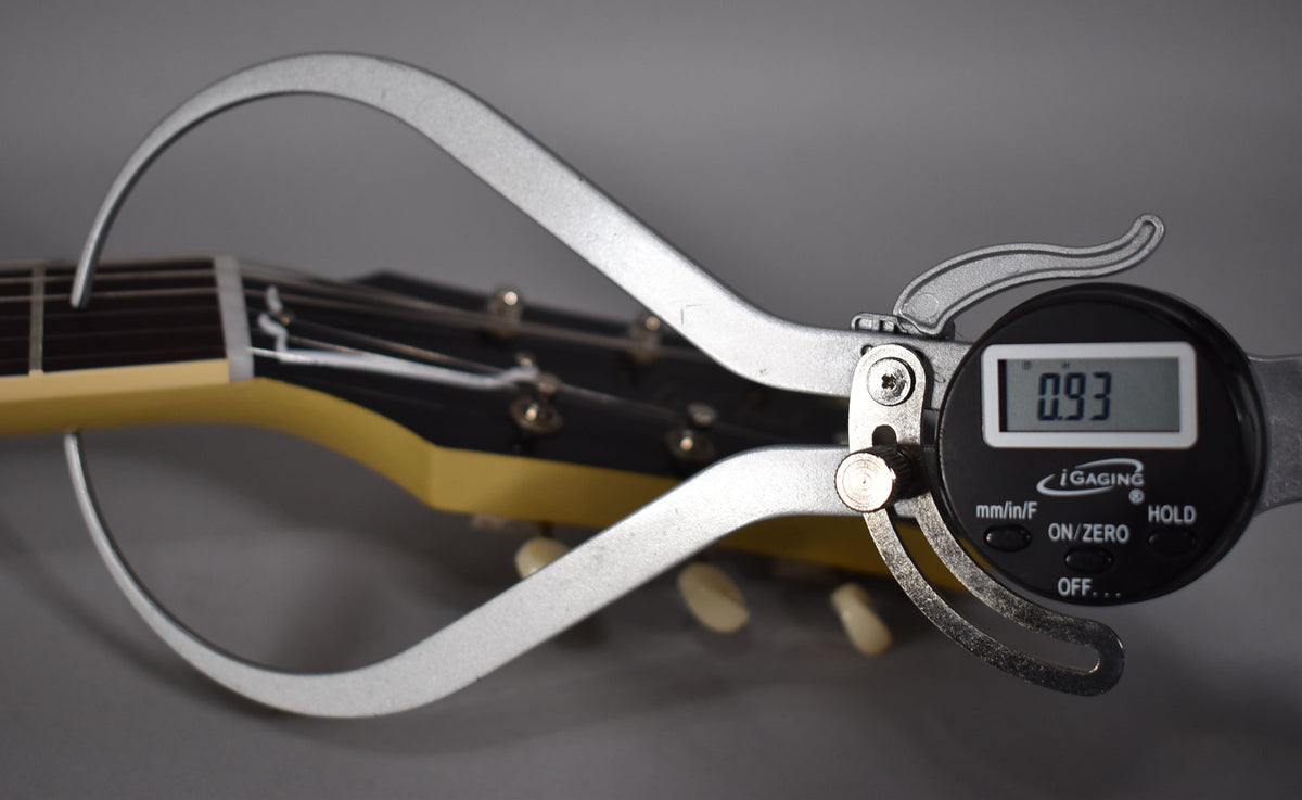 A digital caliper measures the TV Yellow headstock and black fretboard, displaying 0.93.