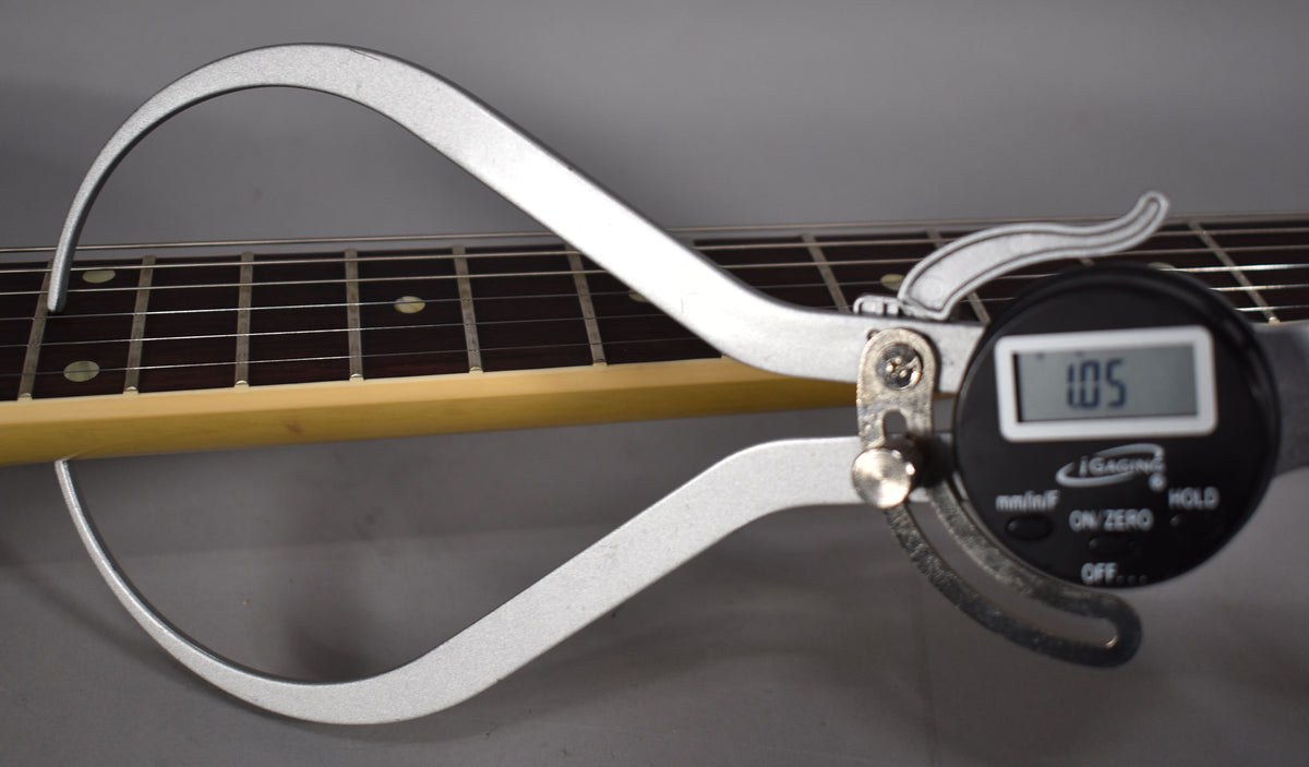 A digital caliper measures the fretboard and neck, showing a reading of 1.05.