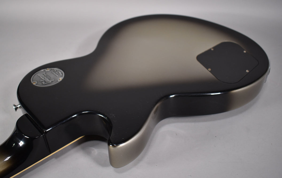 The back of a Les Paul Special, showing a glossy silverburst finish fading from black to silver, with a control cavity cover.