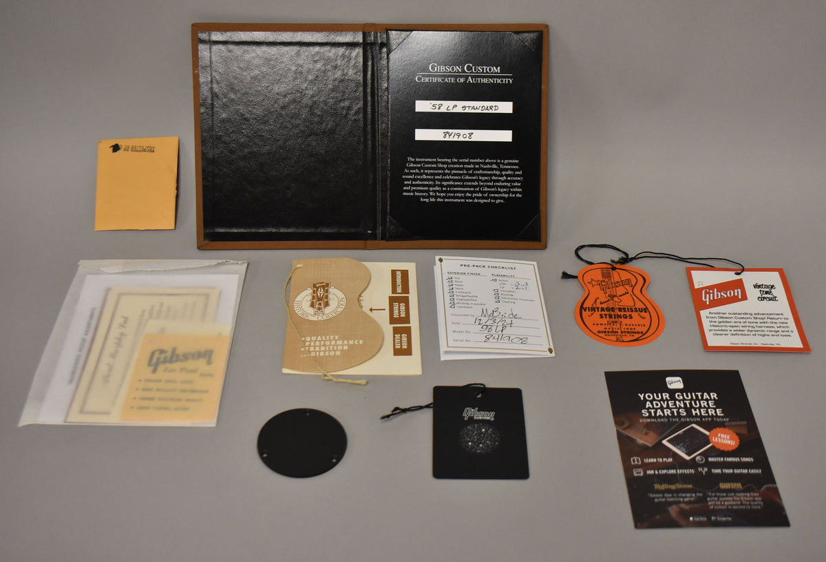 Overhead shot of the guitar's case candy, including a Certificate of Authenticity, hang tags, and various paperwork.