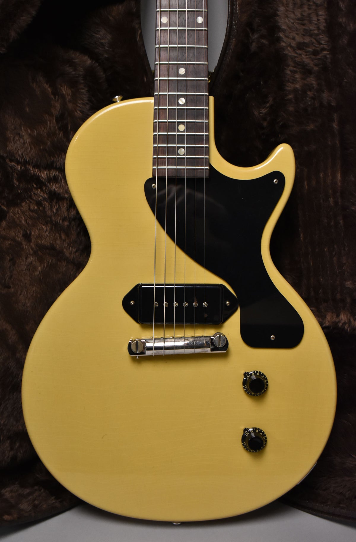 Full-frame, front view of a TV Yellow single-cut guitar with a black pickguard, single P90 pickup, and two black control knobs.