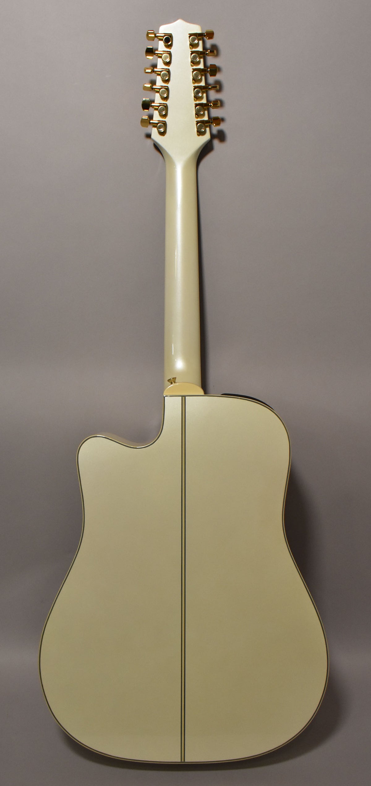 Full rear view of a pearl white 12-string acoustic-electric guitar with a cutaway, gold tuners, and a subtle center seam.