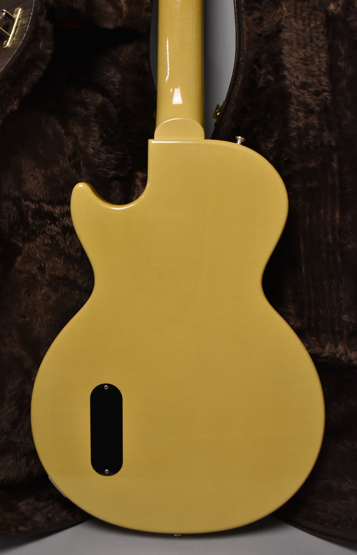 The back of a TV Yellow electric guitar, showing the neck joint, strap button, and a black control cavity cover.