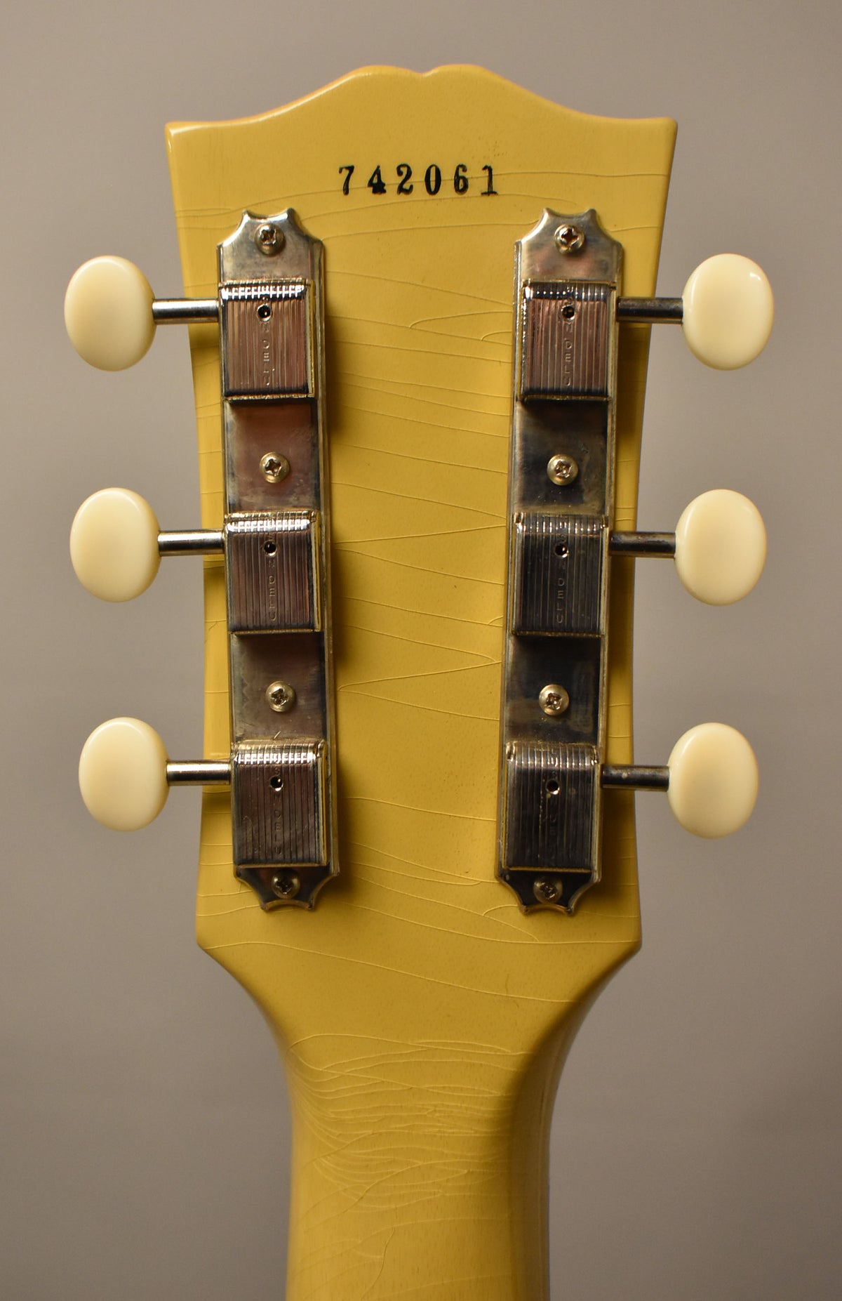 The back of the TV Yellow headstock and neck show extensive finish checking, with six cream-button tuners and a serial number.