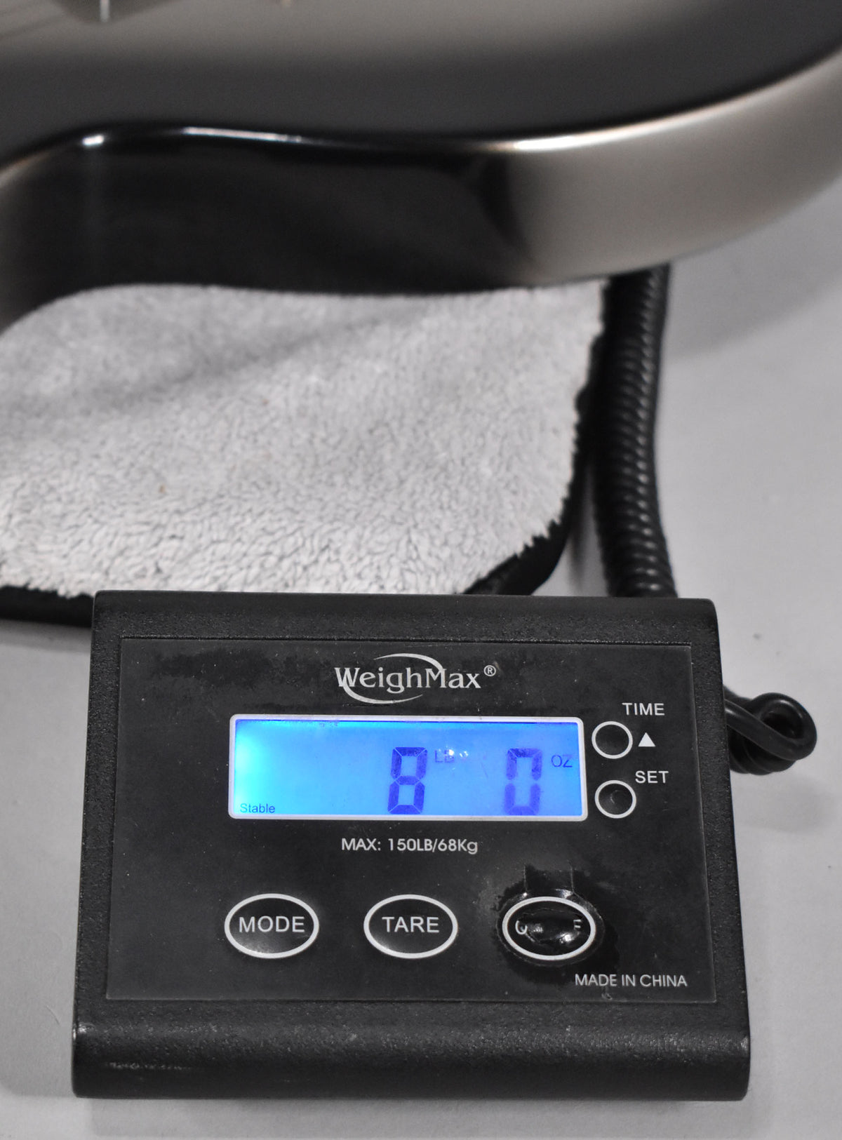 The guitar's body, in Antique Silverburst, rests on a grey towel atop a scale displaying "8 lbs 0 oz".