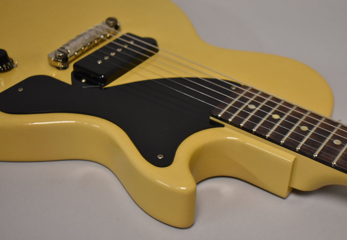 The TV Yellow guitar body is angled, showing the black pickguard, P90 pickup, and part of the fretboard with dot inlays.