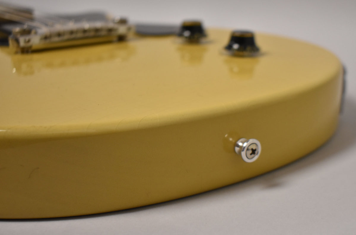 Close-up of the TV Yellow body with a strap button on the lower bout, showing light finish checking and two control knobs in the background.