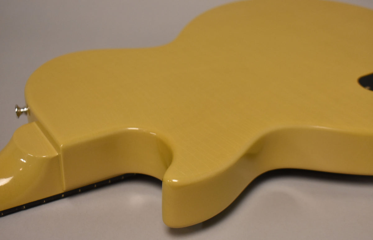The back of a TV Yellow guitar, angled from the neck joint towards the lower bout, showing light finish checking and a strap button.