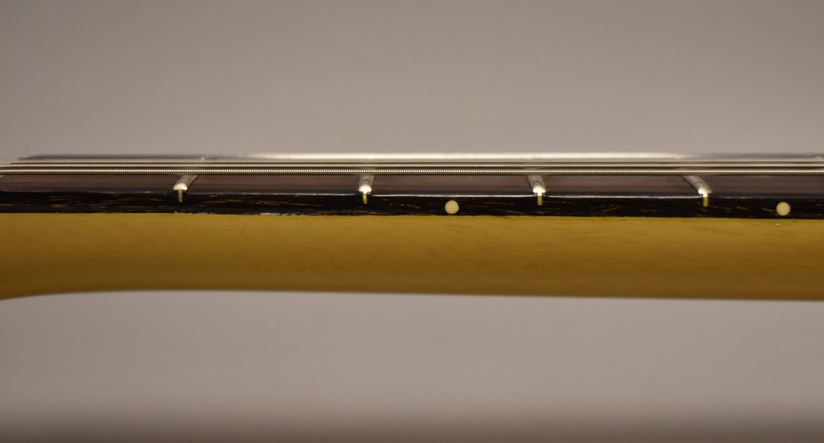 Close-up of the TV Yellow neck and dark fretboard with white dot inlays, showing light wear and checking on the finish.
