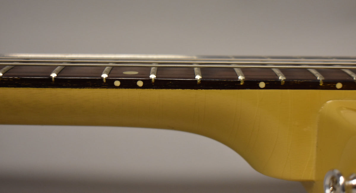 Close-up of the TV Yellow neck and dark fretboard with white dot inlays, showing light finish checking and string wear.