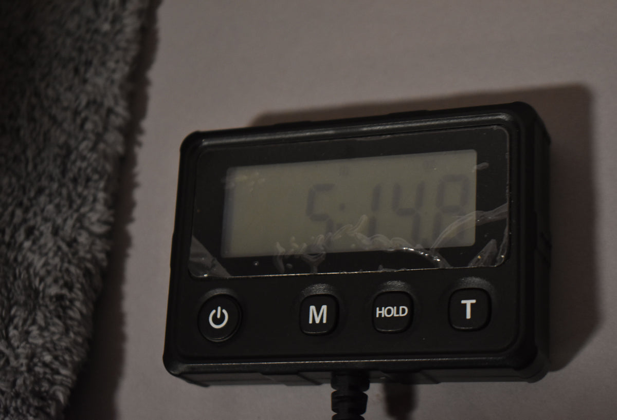 A digital scale shows a reading of "5.148" with a power button, "M", "HOLD", and "T" buttons visible below the screen.