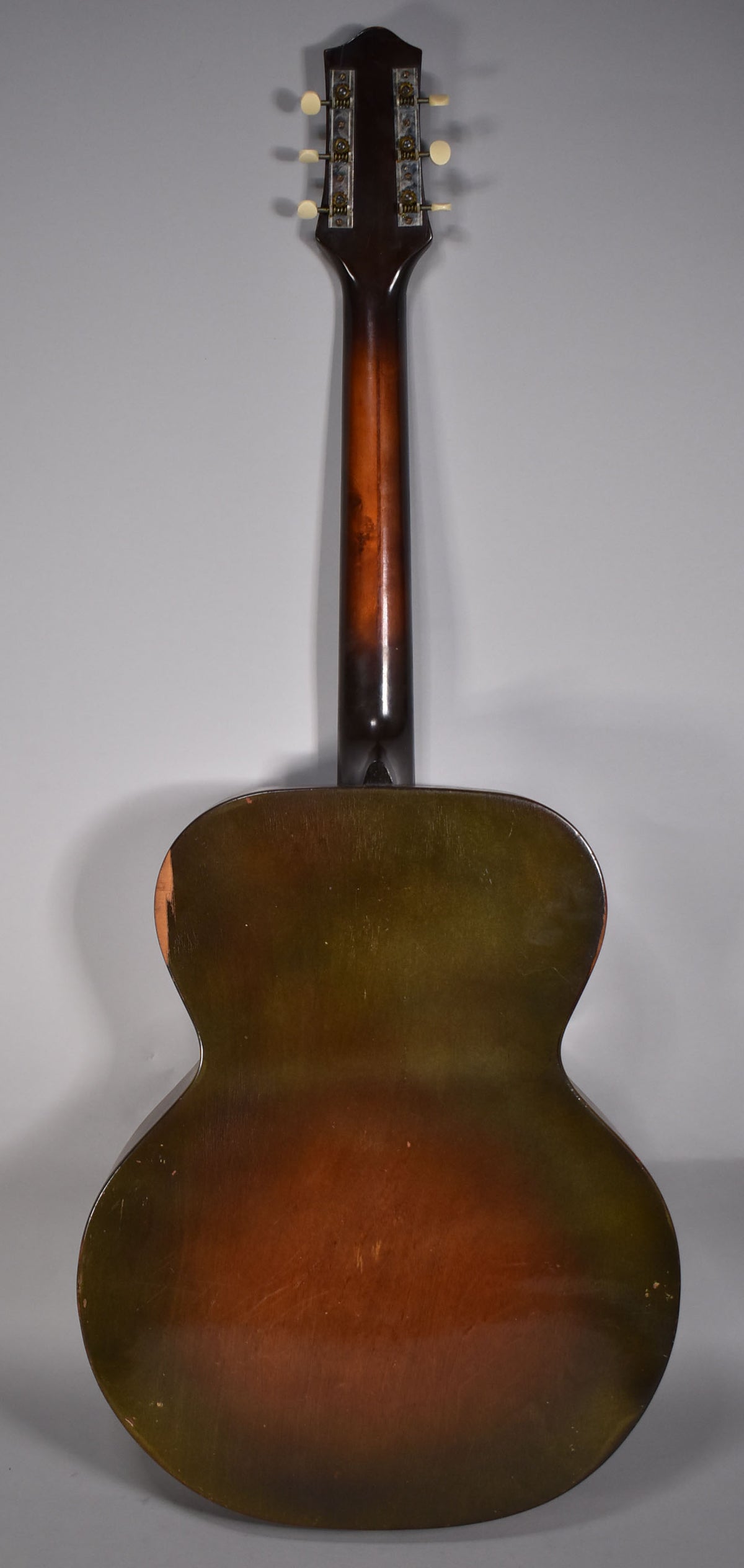 The guitar's back, neck, and headstock are visible, showing a dark brown-to-orange sunburst finish with significant wear and scratches.