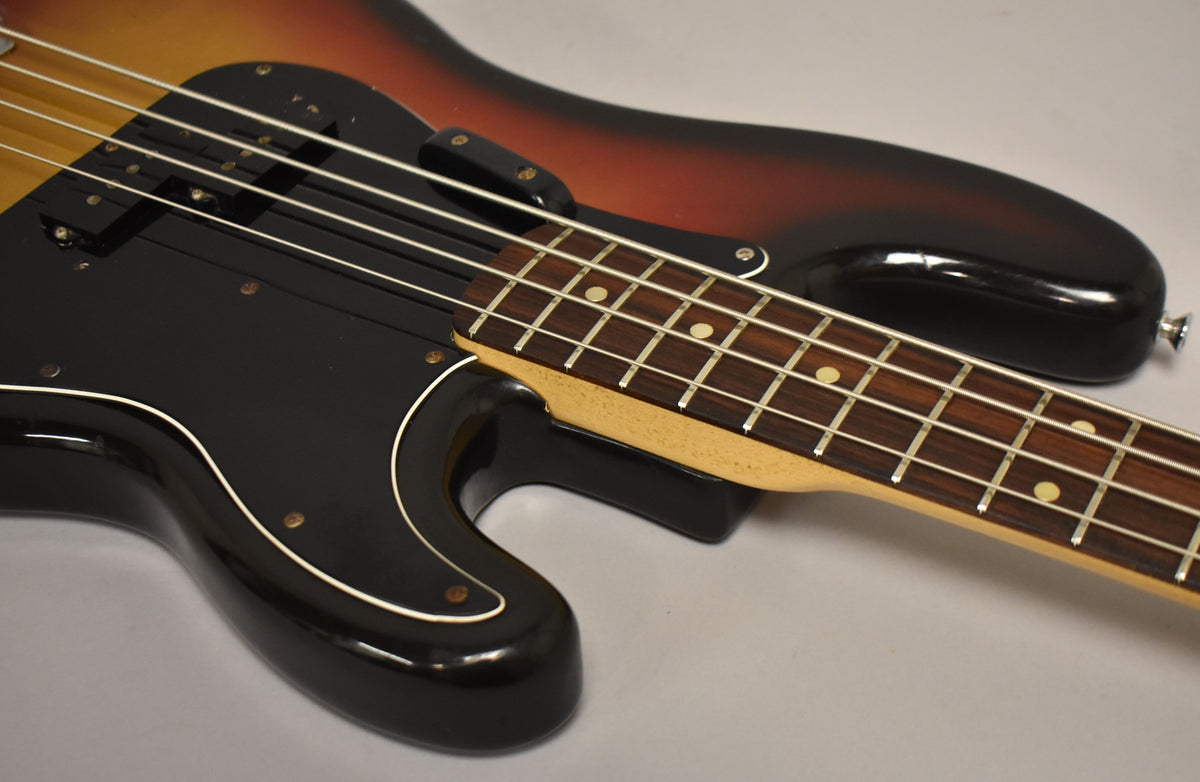 Sunburst bass body with black pickguard and split pickup, showing the maple neck and rosewood fretboard with dot inlays.