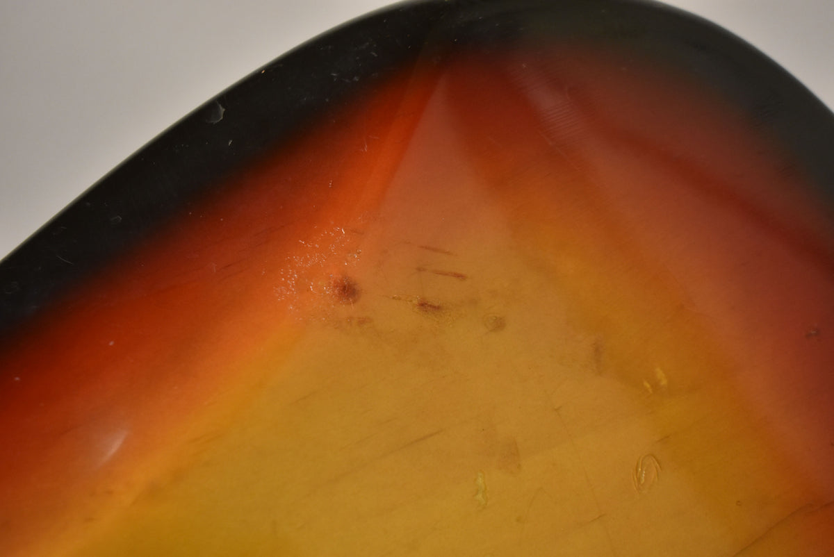 Close-up of the sunburst body's upper horn, showing finish wear, scratches, and small dings on the glossy surface.
