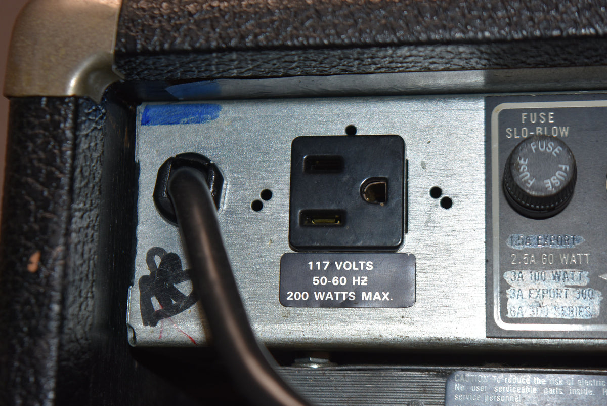 Close-up of the amp's rear panel, showing the power input, a 117V label, and a fuse cap with some wear and blue marks.