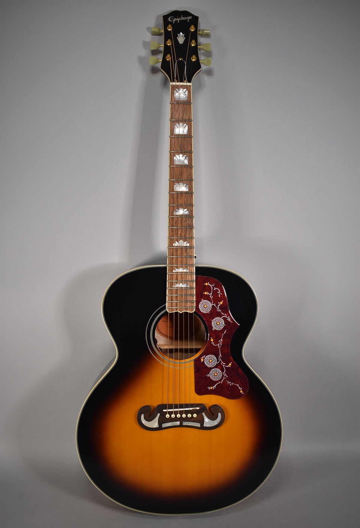Full-length view of a J-200 acoustic-electric guitar with a dark sunburst finish, ornate pickguard, and crown fretboard inlays.