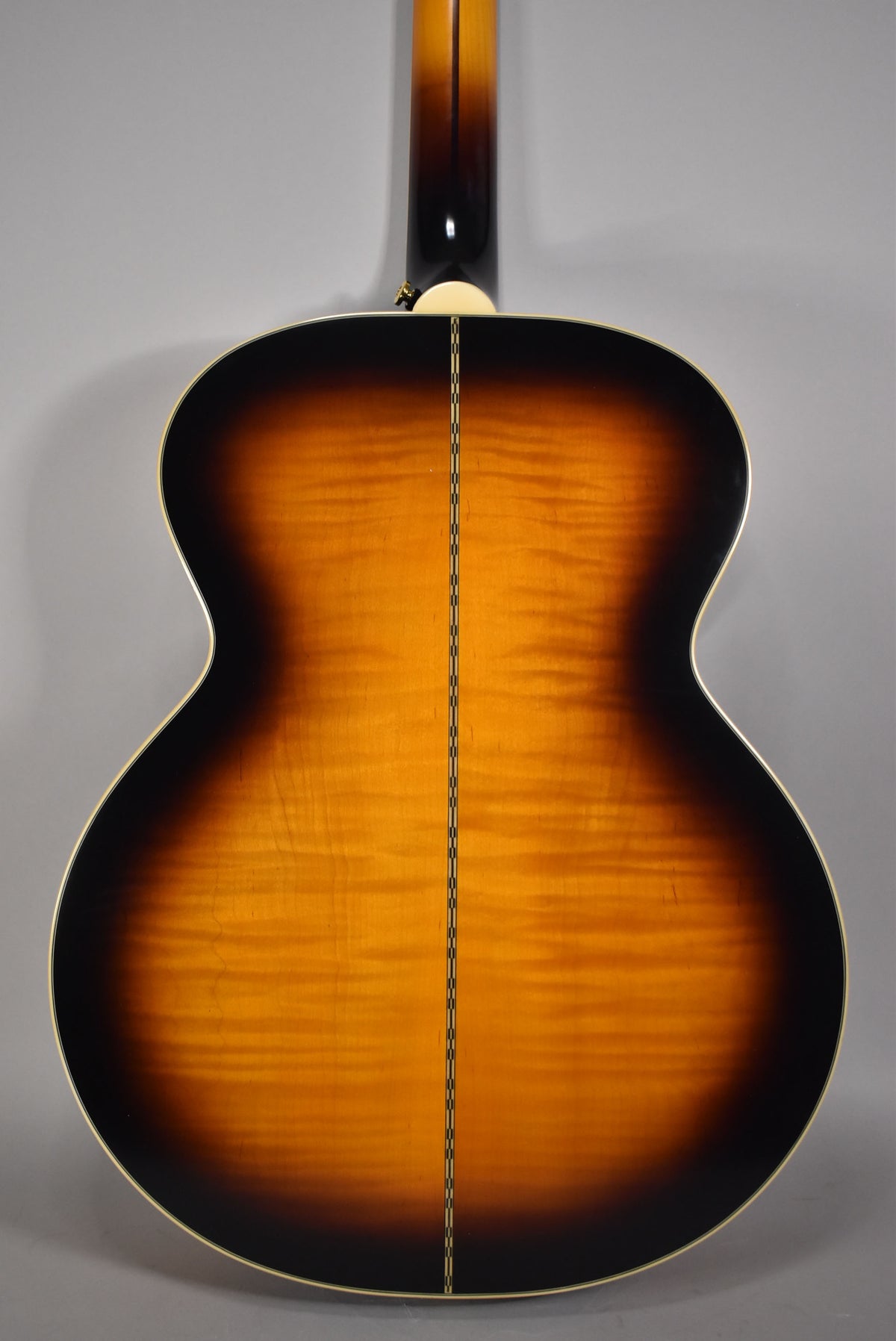The guitar's back, in aged vintage sunburst gloss, shows a flame maple grain and a two-line center seam with white binding.