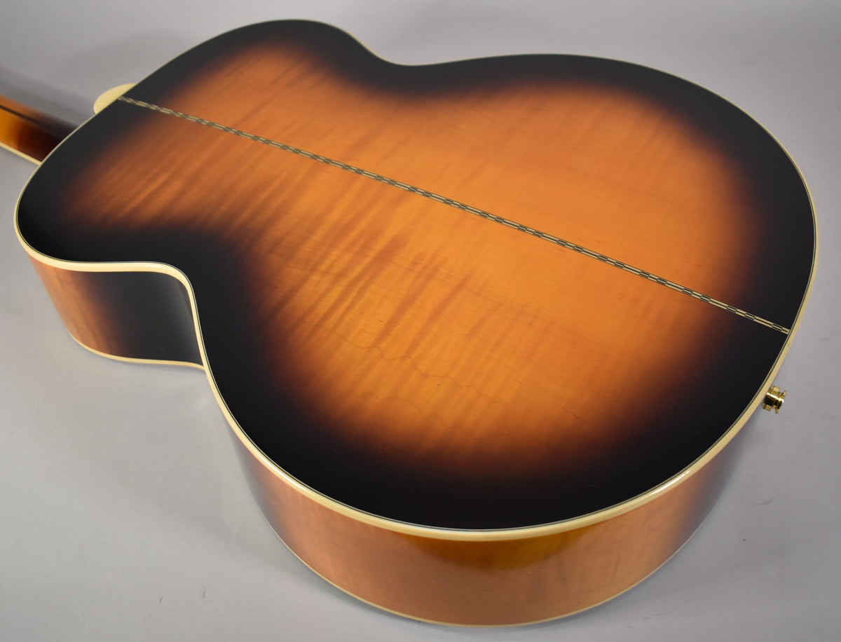 The back of the guitar shows a glossy, aged vintage sunburst finish with a visible center seam and light wood grain.