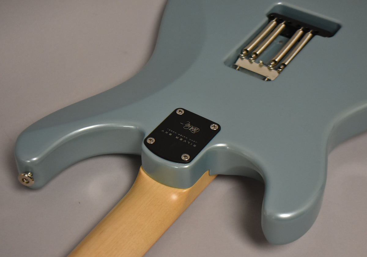 The back of a light blue guitar, showing the neck joint, tremolo springs, and output jack, all in excellent condition.