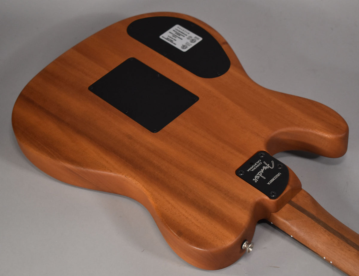 The guitar's back, a warm brown wood with visible grain, features two black control plates and a chrome output jack.