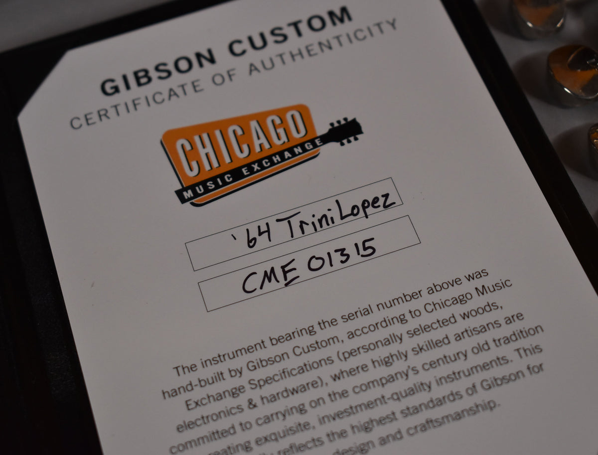 A close-up of the guitar's Certificate of Authenticity, showing the "Chicago Music Exchange" logo and "Trini Lopez" handwritten.