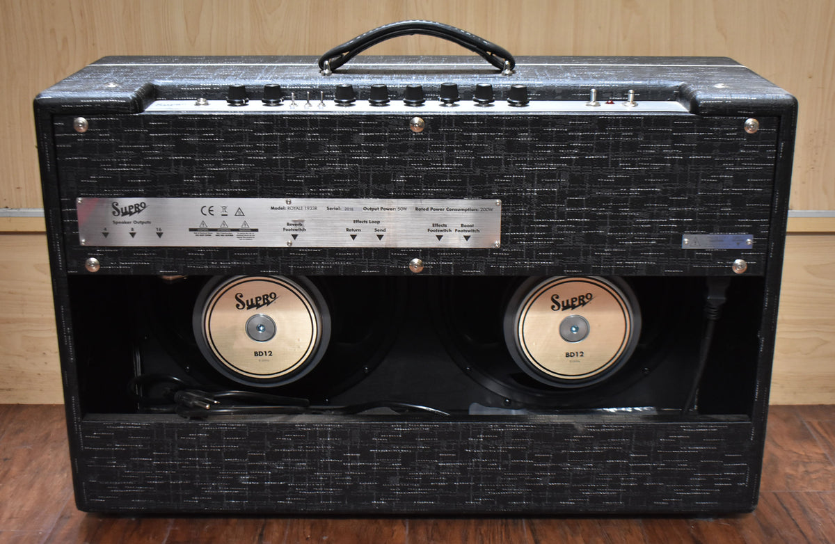 Rear view of a black textured combo amp with two visible gold-coned speakers and a silver control panel with black knobs.