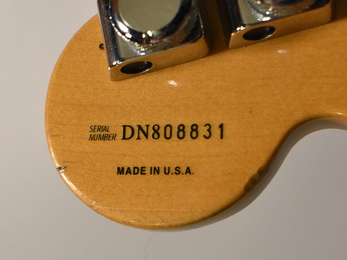 Close-up of the maple headstock's back, showing the serial number and "MADE IN U.S.A." with some minor finish wear.