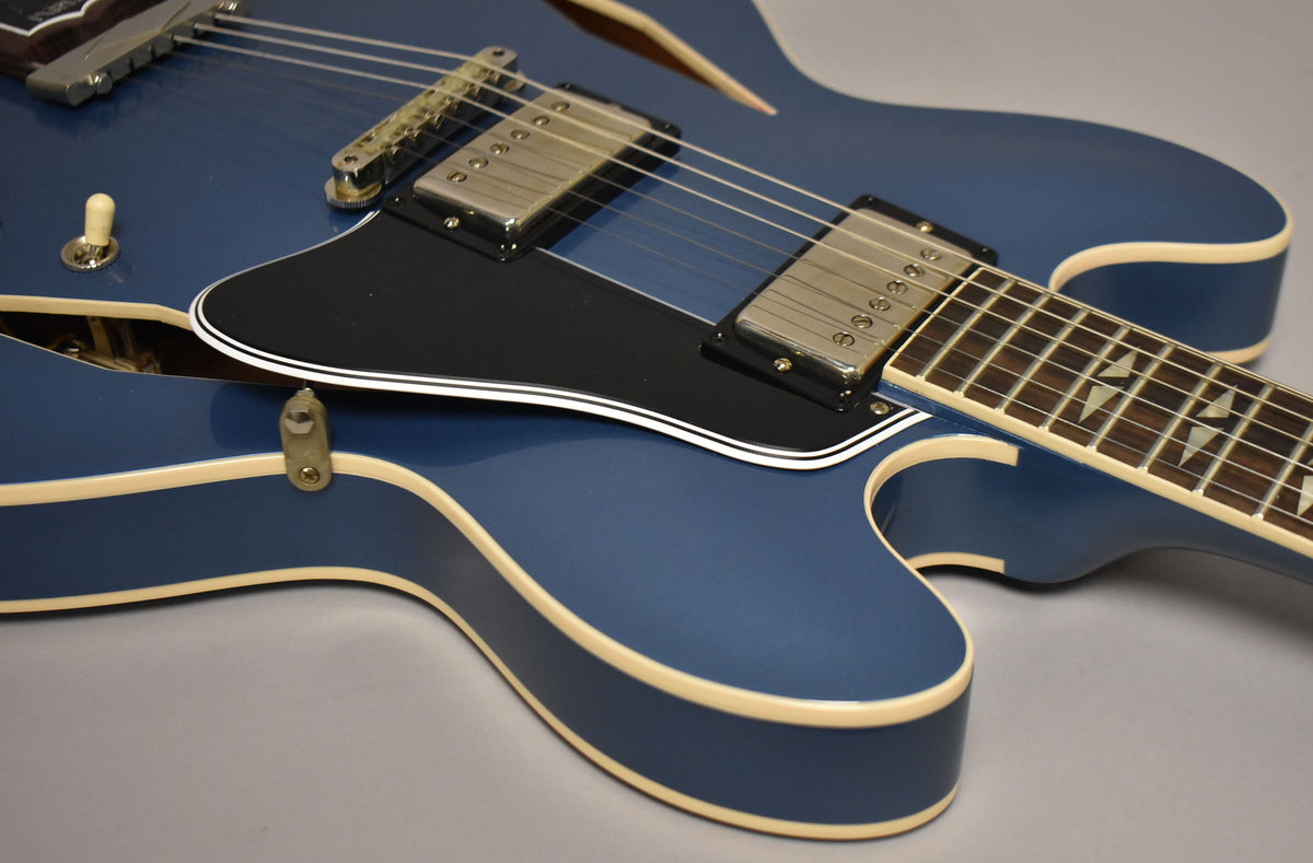 Close-up of the Pelham Blue semi-hollow body, showing the black pickguard, two chrome humbuckers, and trapezoid fretboard inlays.