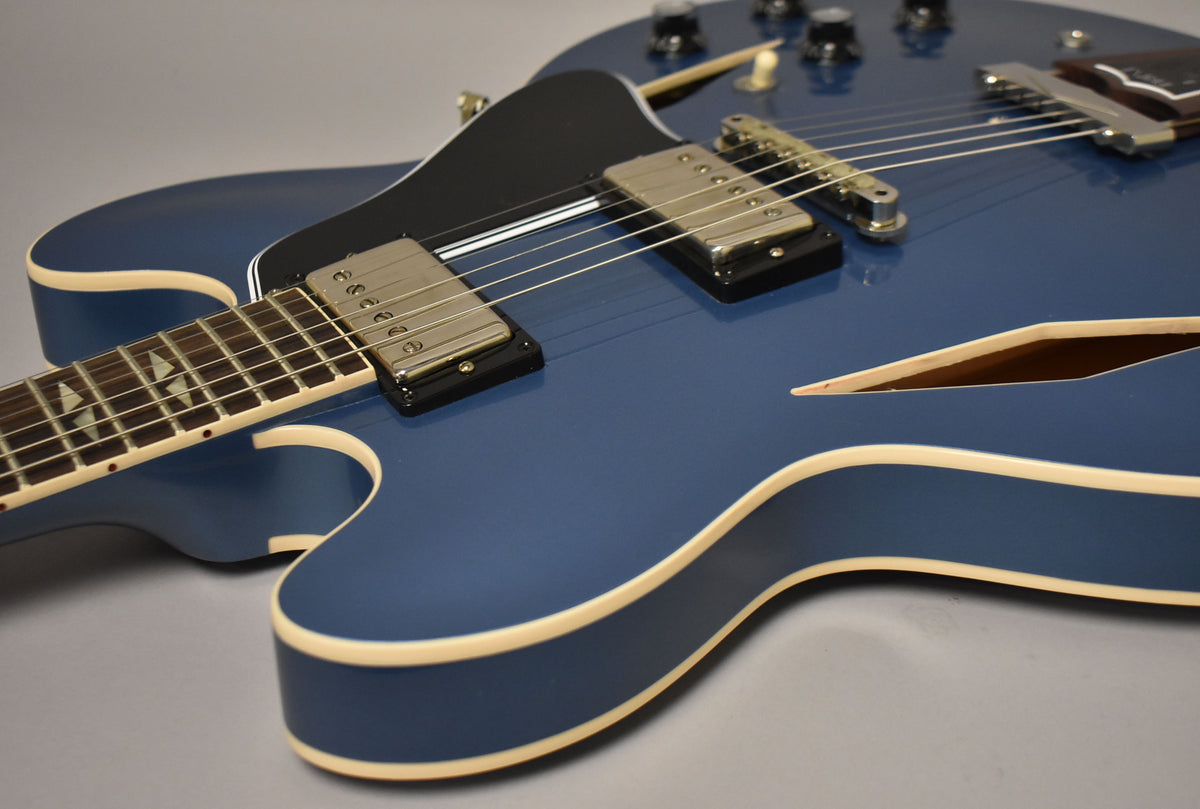 Close-up of the Pelham Blue guitar body, showing the neck, two humbuckers, black pickguard, and f-hole with cream binding.