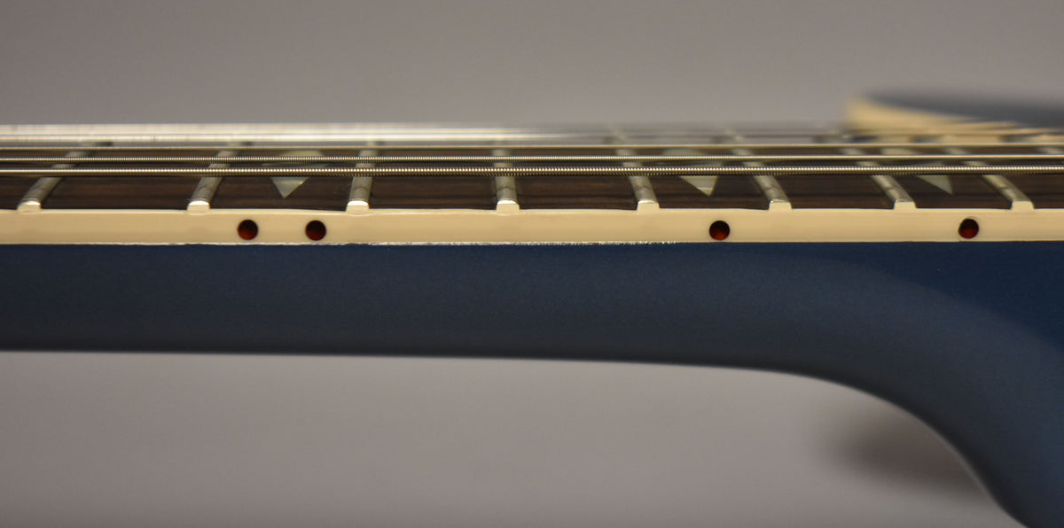 Close-up of the Pelham Blue neck and cream binding with red side dots, showing the dark fretboard and trapezoid inlays.
