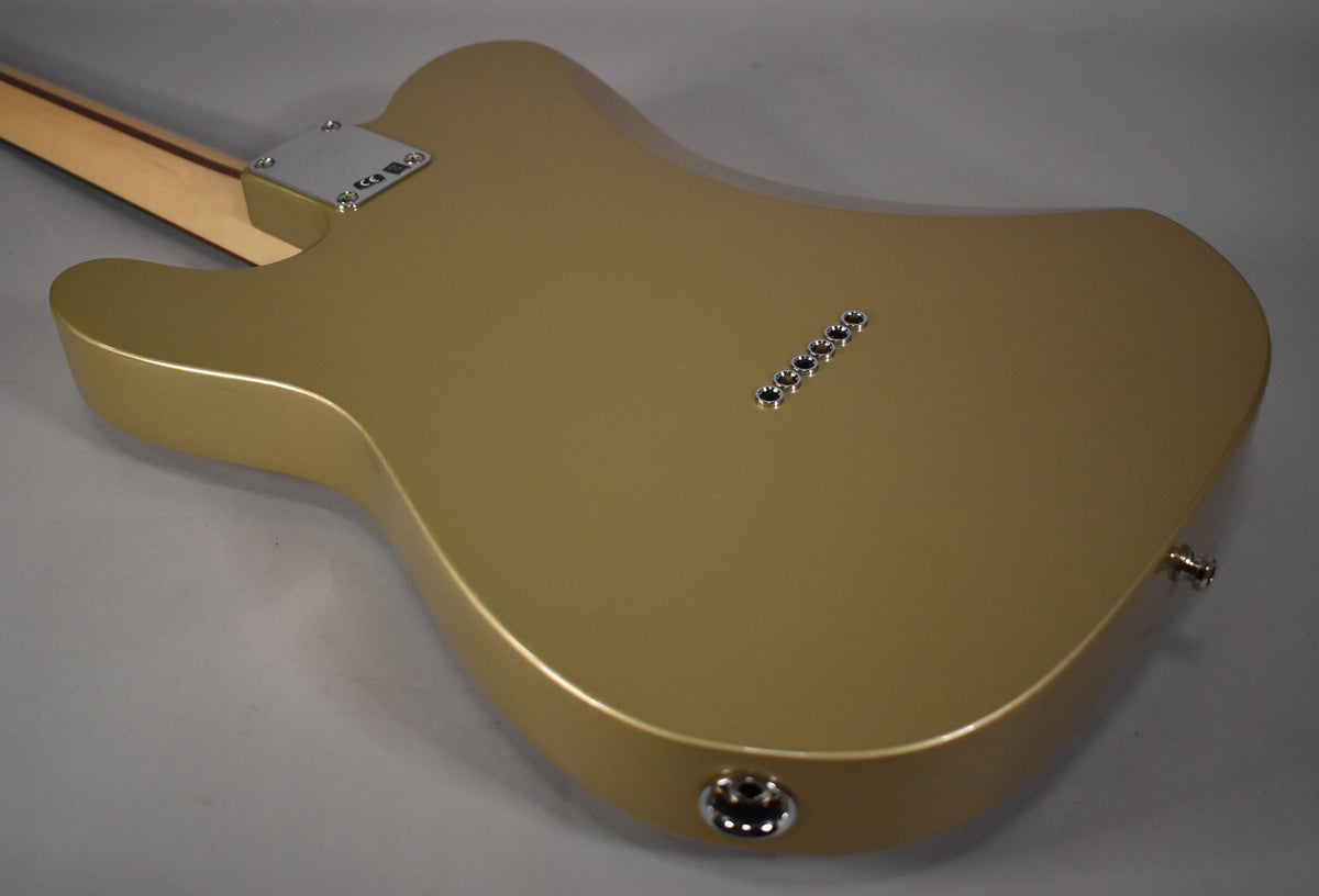 The Shoreline Gold guitar body, viewed from the back, shows a neck plate, six string ferrules, and a chrome output jack.