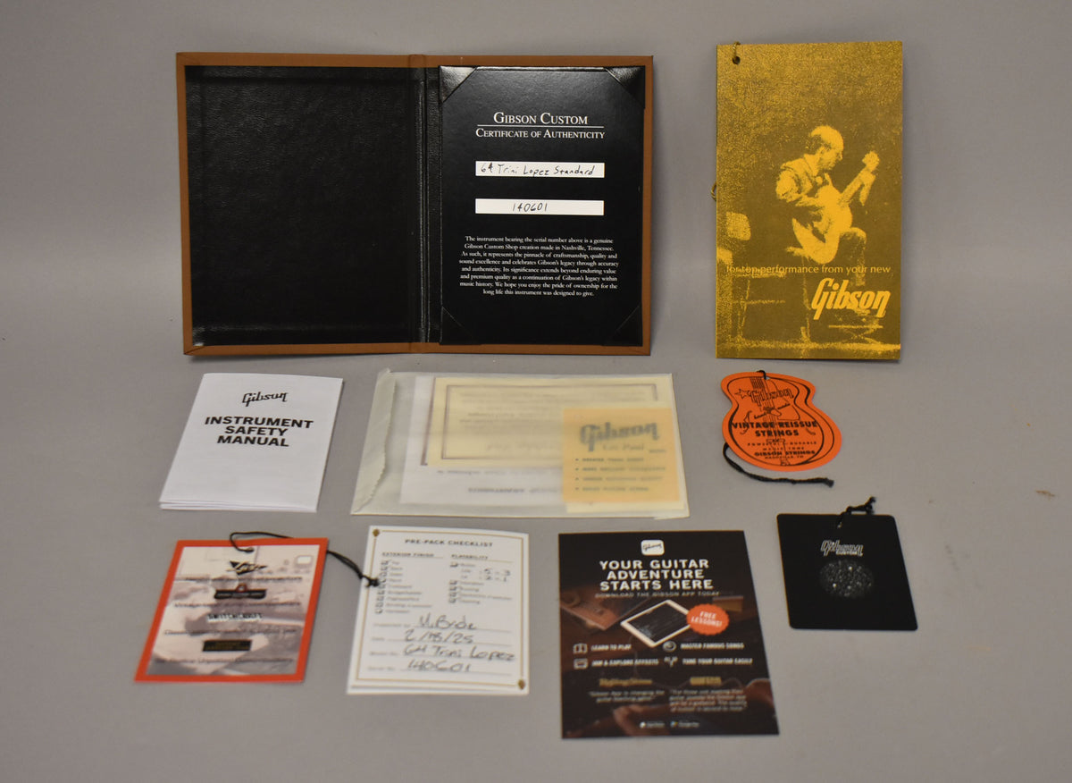 A top-down view of the guitar's case candy, including a certificate of authenticity, manuals, hang tags, and a pre-pack checklist.