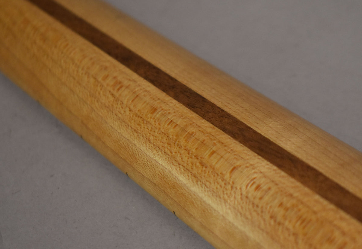 The maple Stratocaster neck's back is angled, showing a dark wood skunk stripe and subtle flame figuring on the light wood.