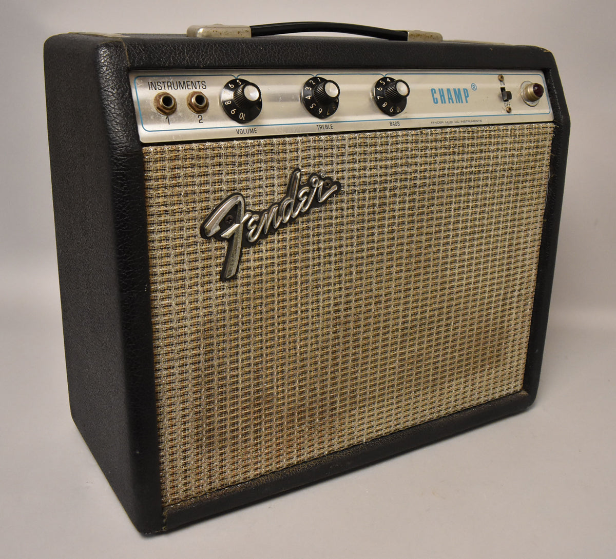 Black tolex combo amp, angled view, showing a silverface control panel with three black knobs, two inputs, and a tan grille.