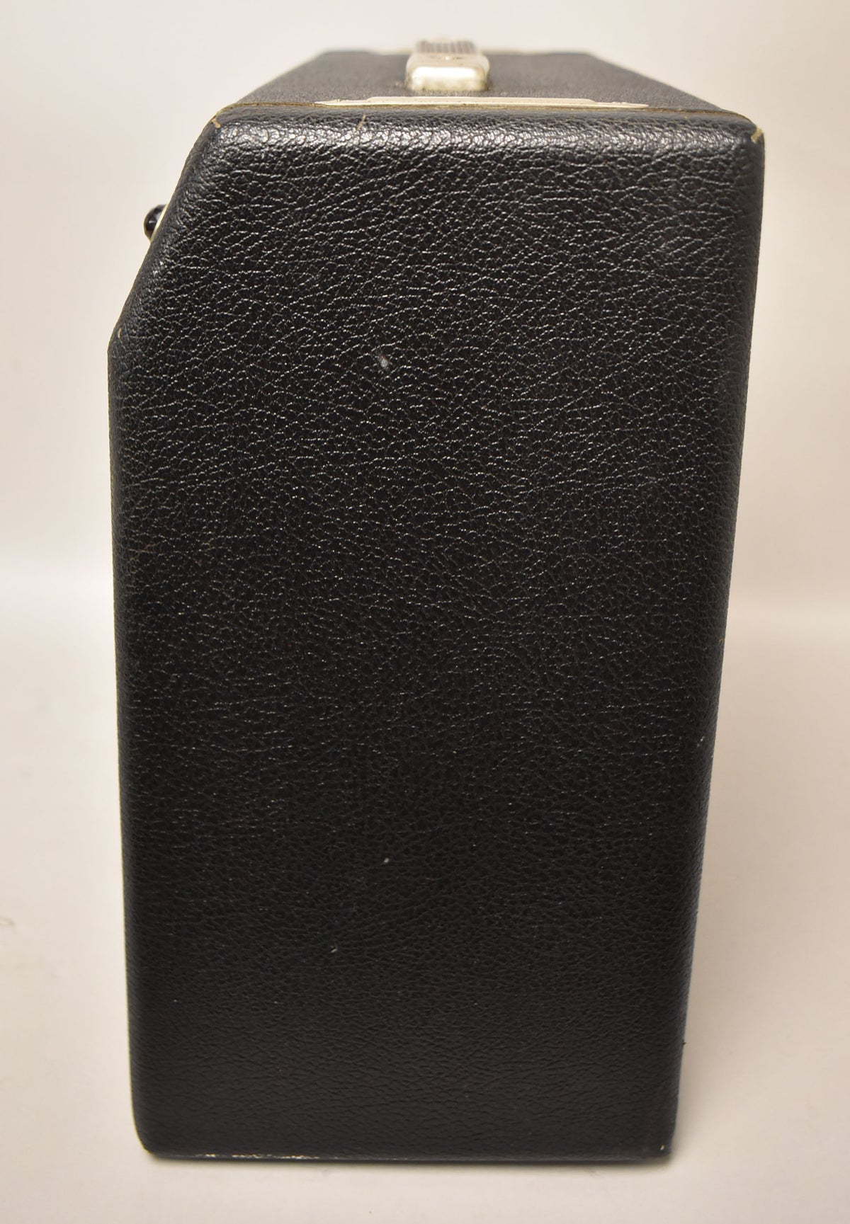 The amplifier's right side, covered in black textured tolex, shows minor scuffs and a small white handle on top.