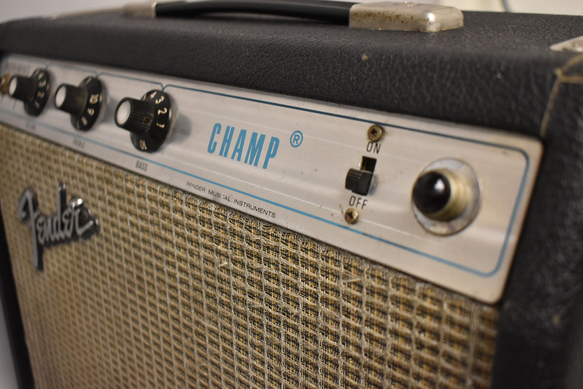 Close-up of the amp's silverface control panel and tan grille cloth, showing three black knobs, a power switch, and an input jack.