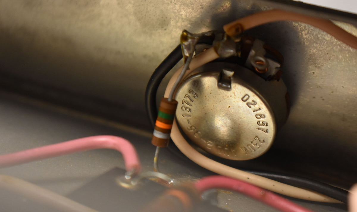 Close-up of the amplifier's internal wiring, showing a brass potentiometer with visible numbers and colorful resistors.