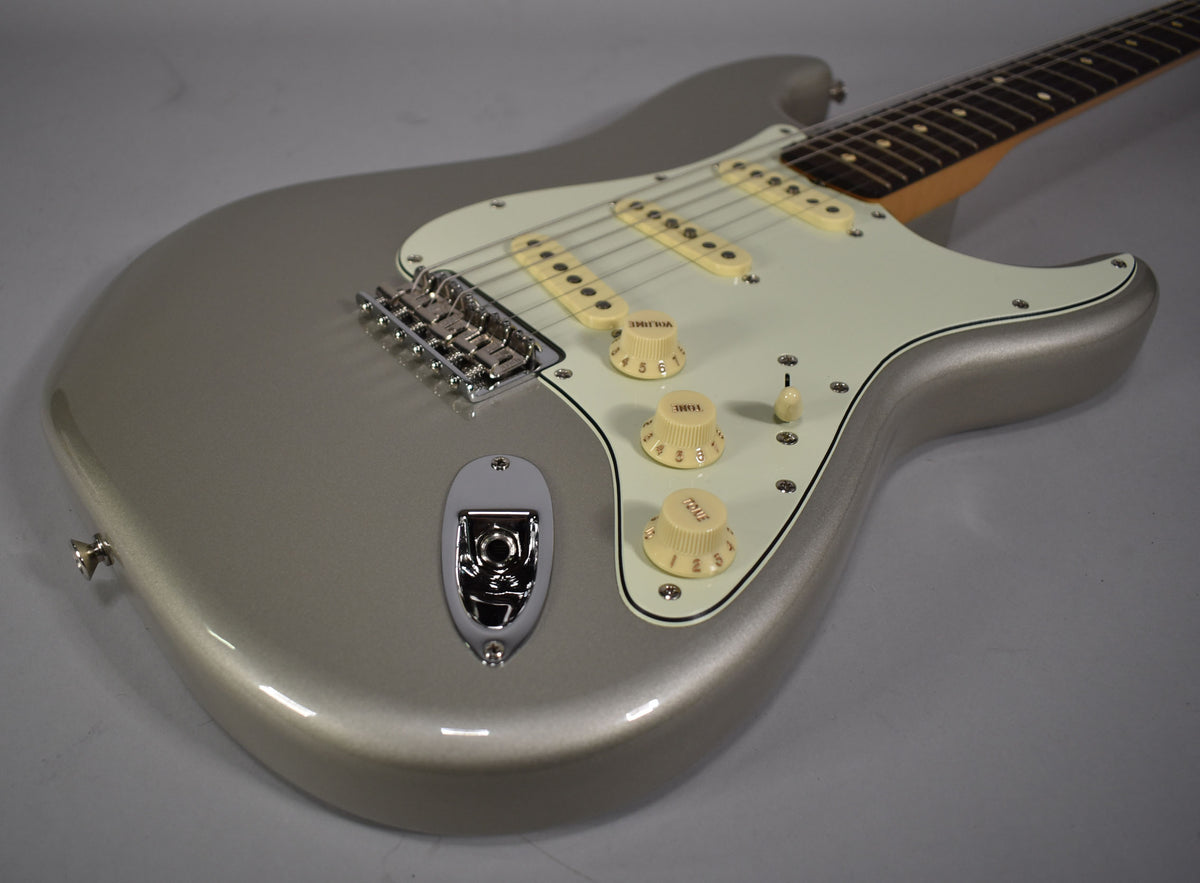 The Inca Silver Stratocaster body is angled from the lower left, revealing a white pickguard, three cream pickups, and matching knobs.