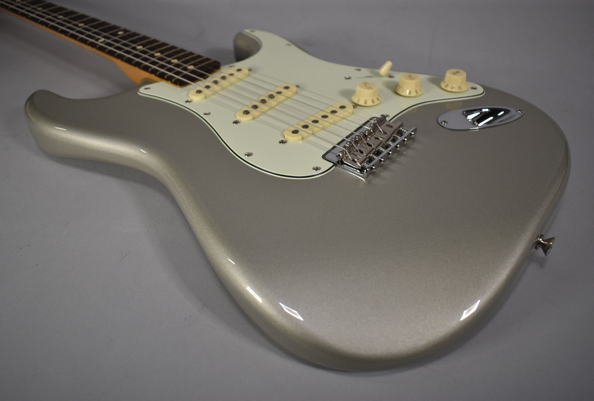 The Inca Silver Stratocaster is angled from the upper left, showing its body, white pickguard, and three cream single-coil pickups.