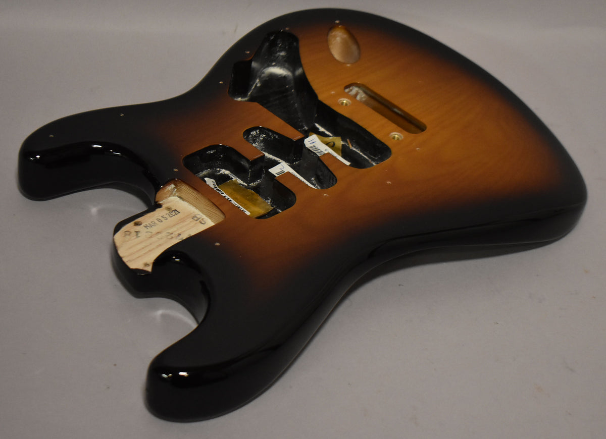 A glossy 2-tone sunburst Stratocaster body, viewed from above, showing the neck pocket and three pickup cavities.