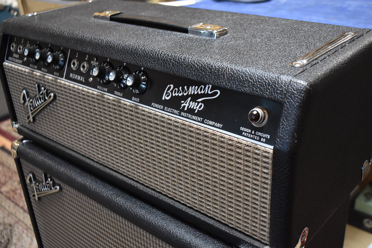 The black textured amp head and cabinet are stacked, showing the silver grille cloth and control panel with black knobs.