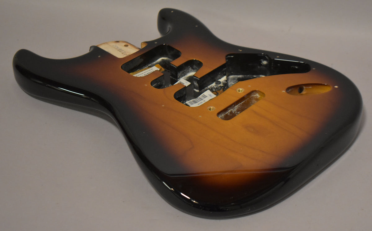 Glossy 2-tone sunburst Stratocaster body, angled from above, showing the upper horn, pickup routes, and output jack cavity.