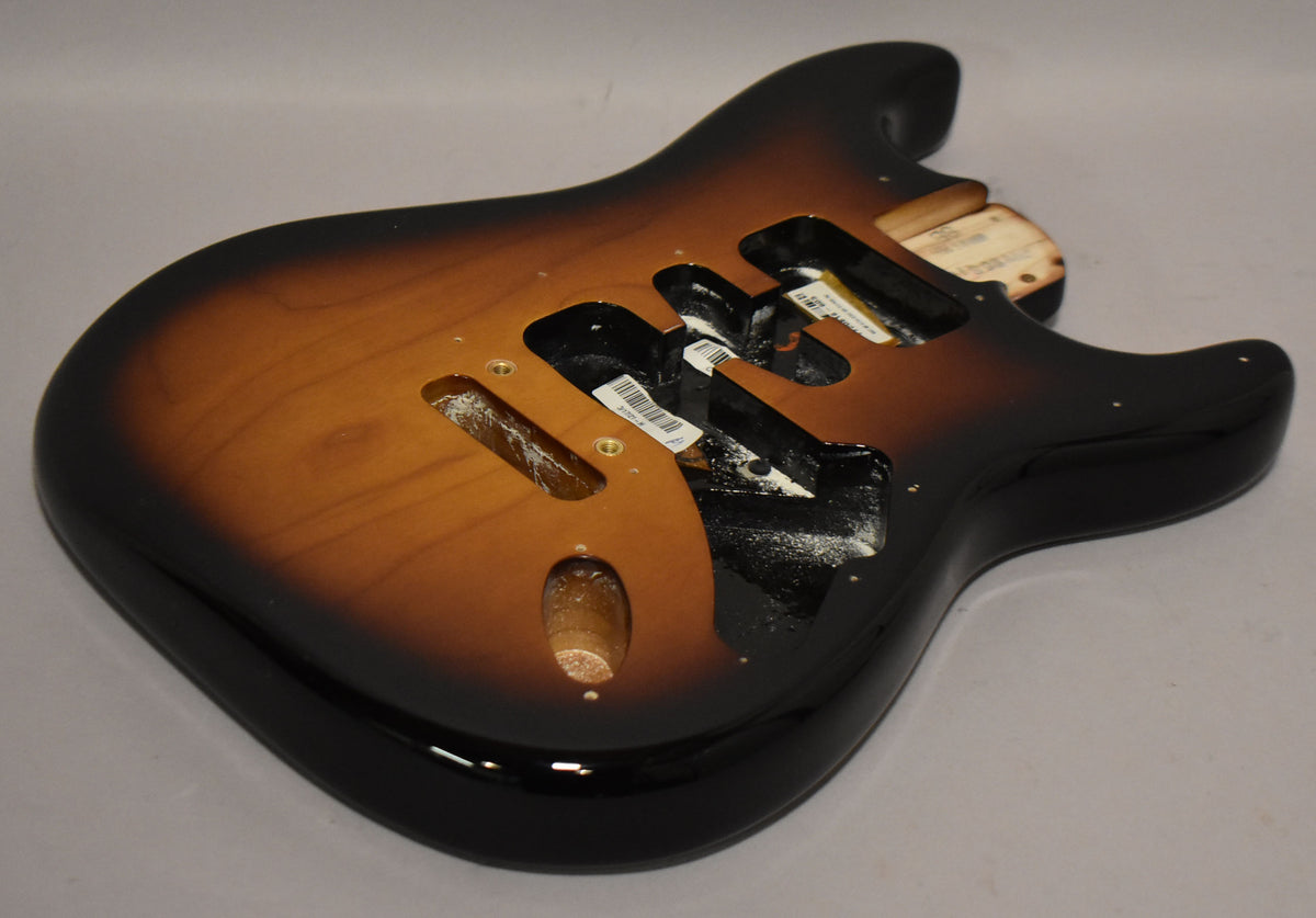 A 2-tone sunburst Stratocaster body, viewed from the upper right, showing the glossy finish and empty pickup and control cavities.