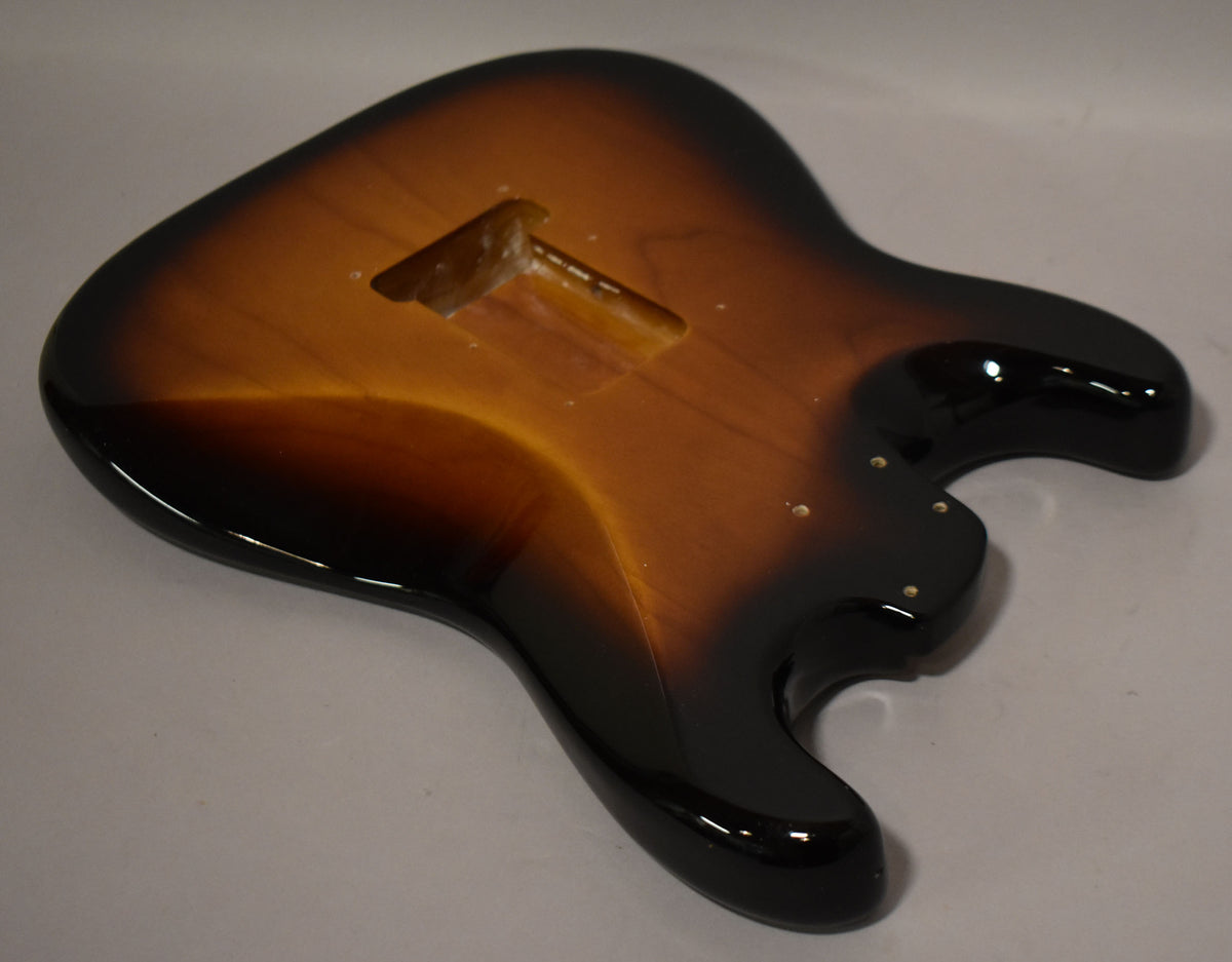 The glossy 2-tone sunburst Stratocaster body is viewed from above, angled to show the upper bout and neck pocket.