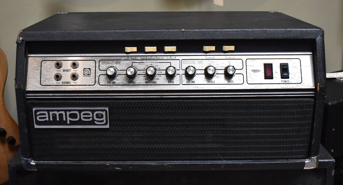 Front view of a black Ampeg SVT amp head with a silver control panel, black grille, and minor wear on the corners.