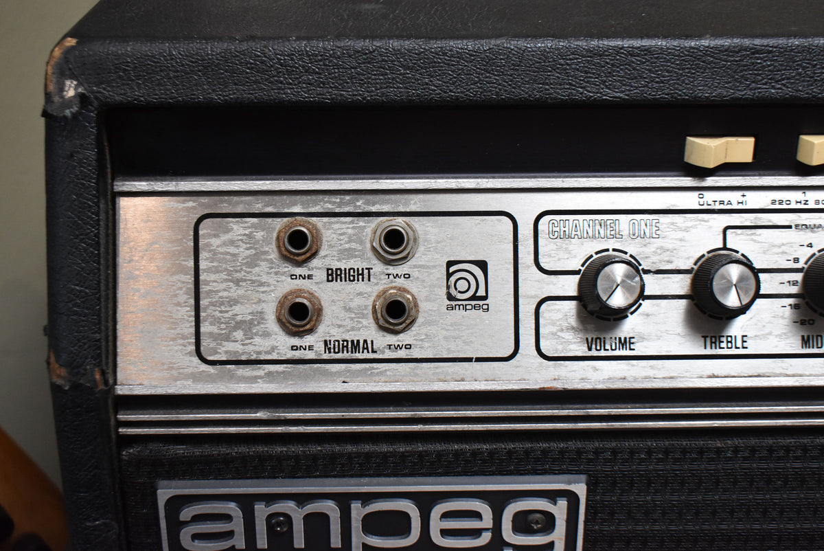 Close-up of the amp's worn silver control panel, showing four input jacks, three black knobs, and two cream rocker switches.