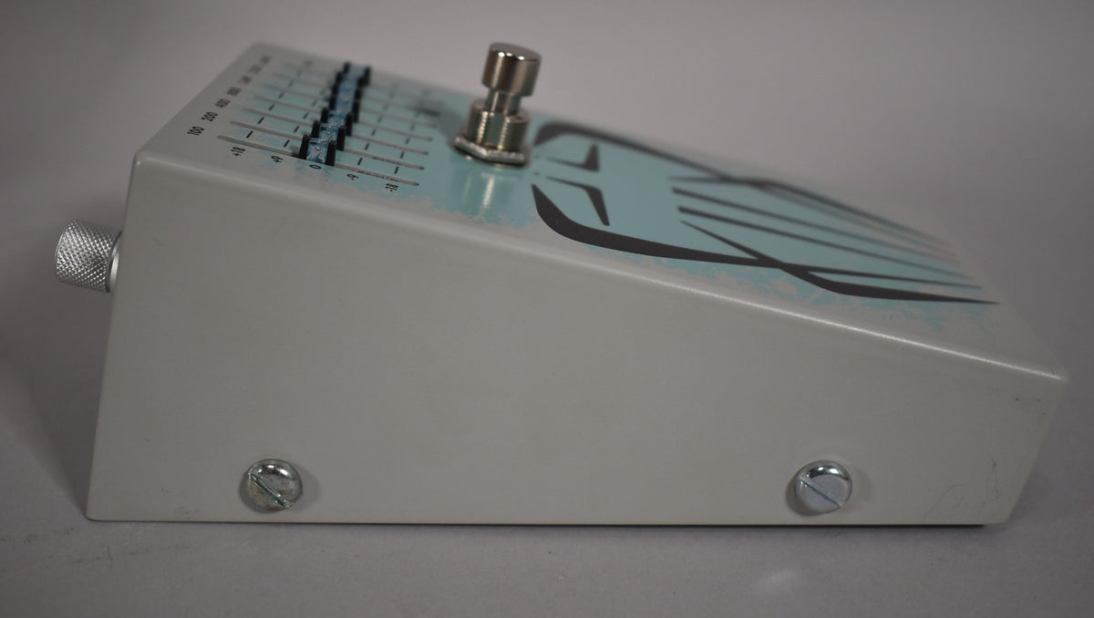 The light grey pedal is angled right, showing the side with two screws and the top with a footswitch and graphic EQ sliders.