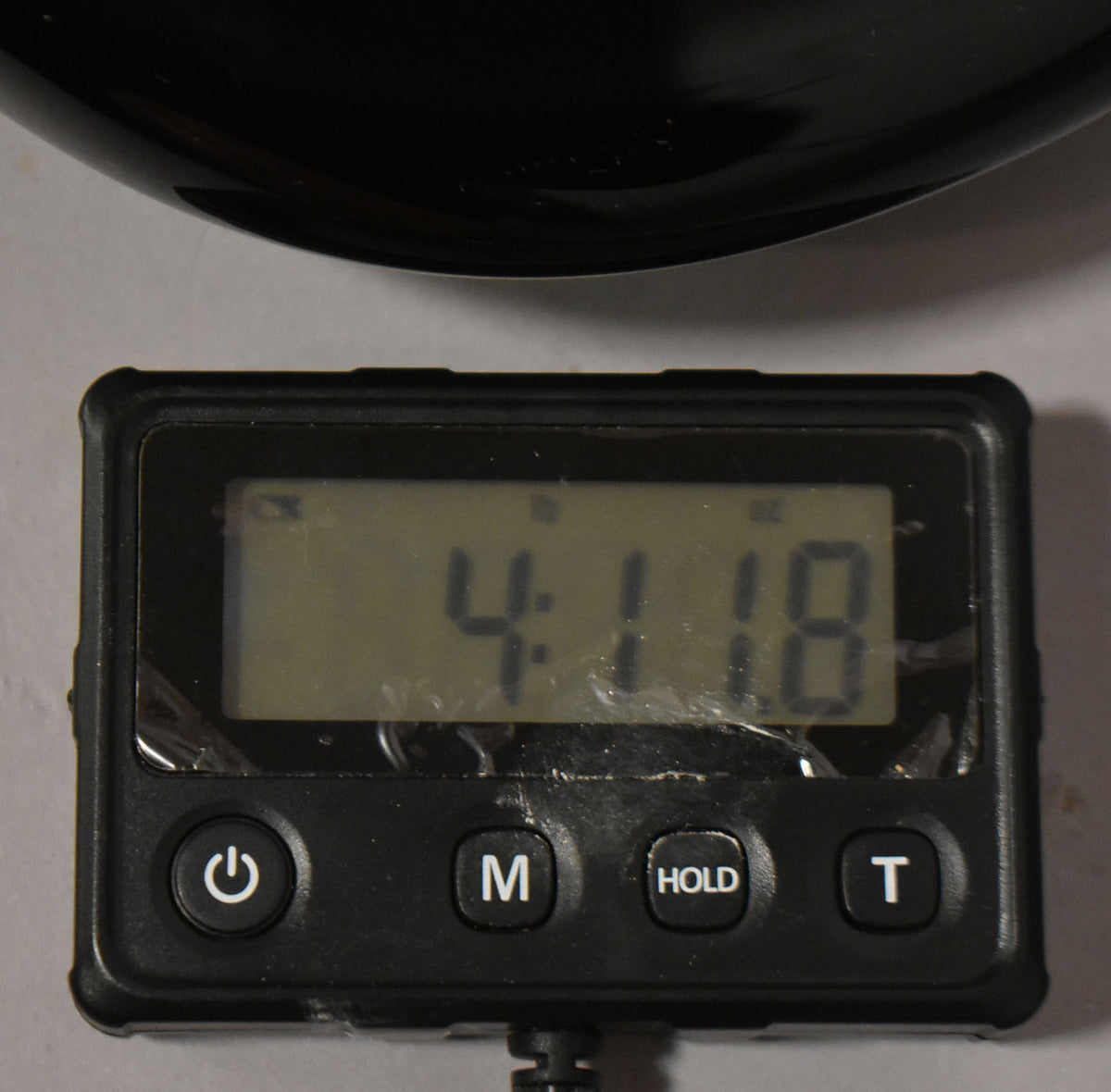 This is a close-up of a digital scale displaying "4:18" with a black guitar body partially visible at the top.